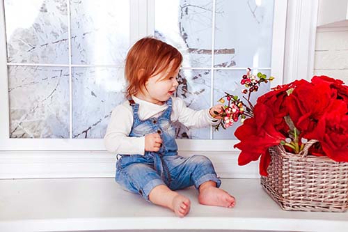 Flicka sitter med blommor. Visuell utveckling hos barn.