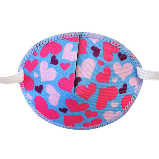 En ljusblå ögonlapp med resår till barn. Den är dekorerad med ljusrosa hjärtan och heter Lovehearts. Den har elastik som sätts runt huvudet och är designad för barn som skelar. Ögonlappen hjälper till vid synträning. Märket är Kay Fun Patch.