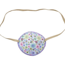 En ögonlapp med resår för vuxna. Den är vit med lila kant och små lila och ljusrosa blommor. Märket är Kay Fun Patch. Den heter Cornflowers.